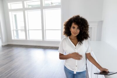 a lovely lady standing in a white and empty room